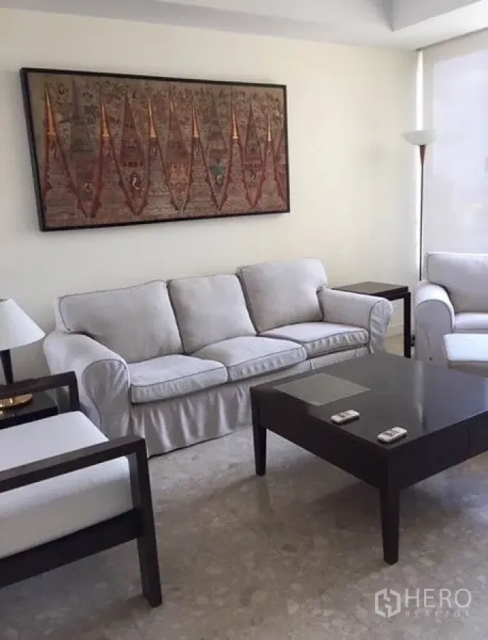 Condominium for rent in Watthana, Bangkok - Bright living room with light grey sofa, wall art and marble floor in a Thonglor condo.