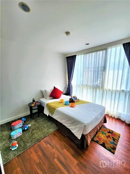 公寓 出租在Bang Rak, Bangkok - 采光充足的单人卧室，落地窗与温暖的木地板。