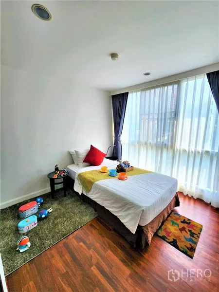 公寓 出租在Bang Rak, Bangkok - 采光充足的单人卧室，落地窗与温暖的木地板。