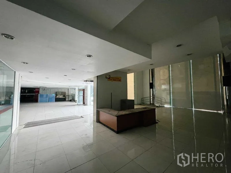 展厅 出租在Min Buri, Bangkok - 铺瓷砖的大堂，落地玻璃与前台区。