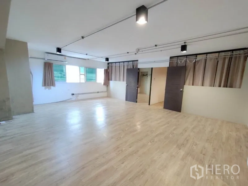 办公空间 出租在Phaya Thai, Bangkok - 明亮开放的工作区，大面积窗户、窗帘与天花轨道灯。