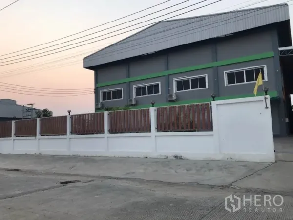 工厂 出售在Pak Kret, Nonthaburi - 灰色工厂外立面，白色围墙与金属大门