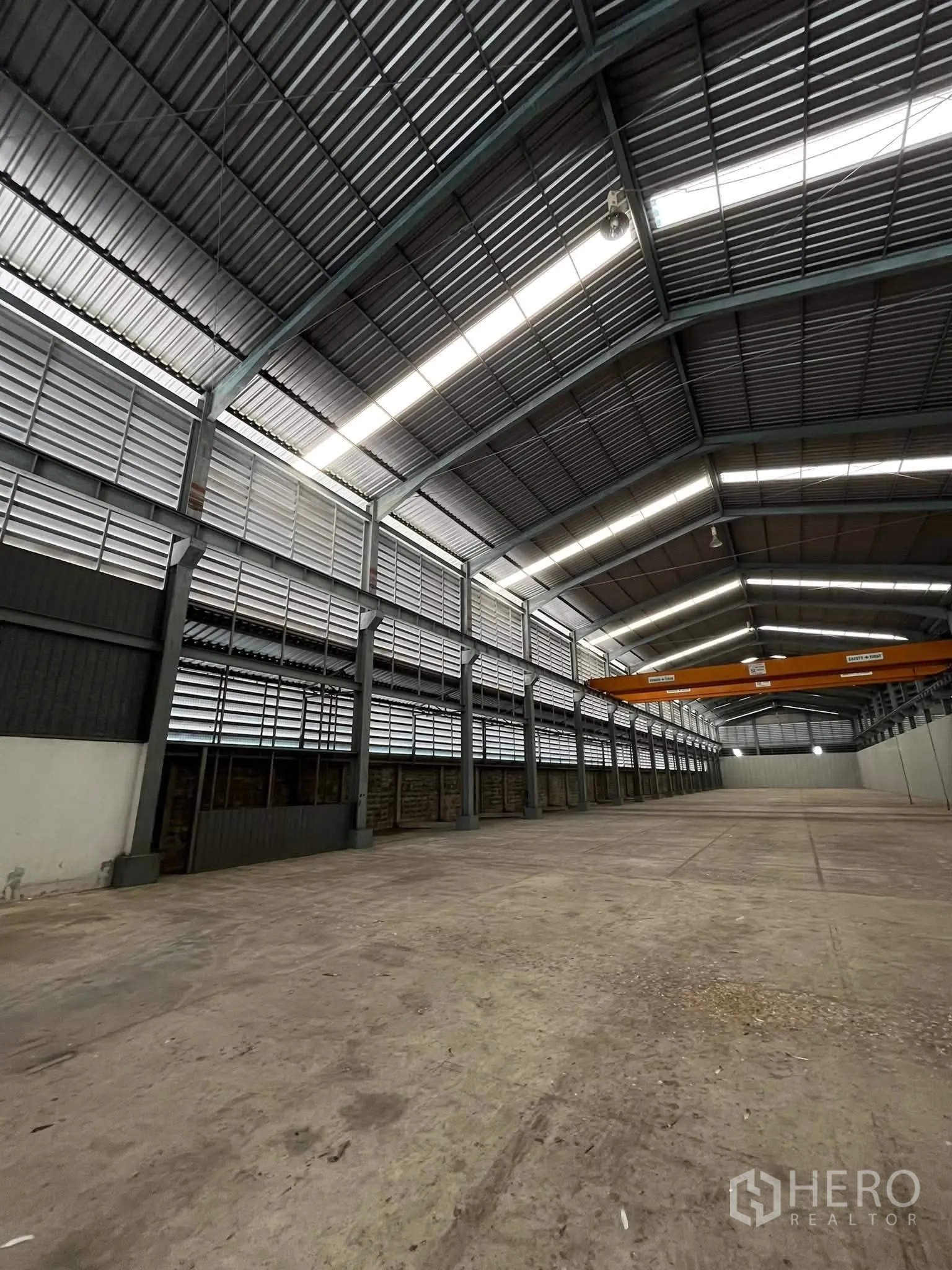 Warehouse for rent in Bang Phli, Samut Prakan - Long warehouse bay with concrete floor, louvered ventilation panels, and skylight strips.