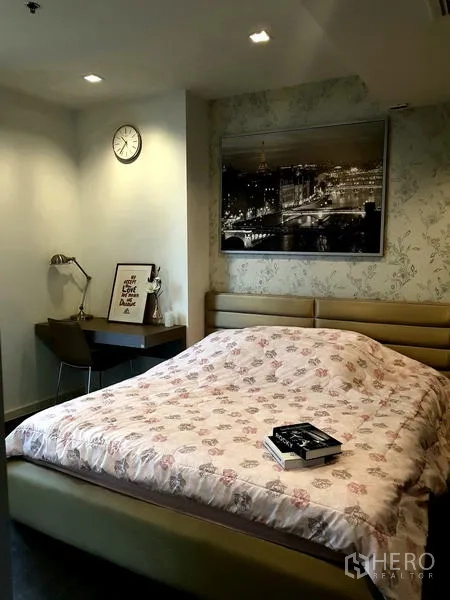 Condominium for rent in Sathon, Bangkok - Master bedroom with soft headboard, floral bedding and work desk.