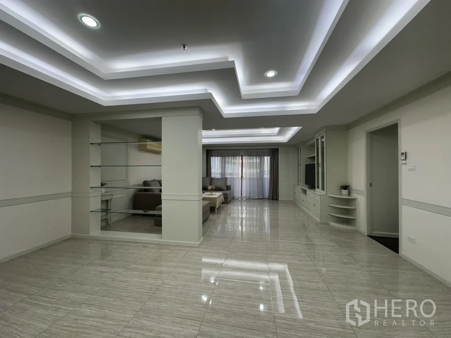 Condominium for rent in Watthana, Bangkok - Expansive open living space with feature shelving and tray ceilings.