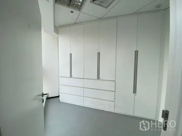 Office Space for rent in Phra Khanong, Bangkok - Private storage room with tall white built-in cabinets and a swing door inside the office unit.