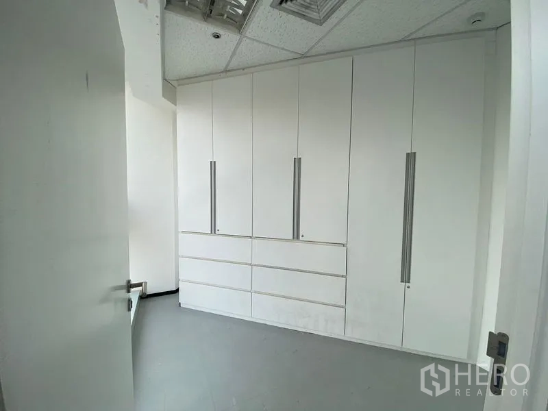 Office Space for rent in Phra Khanong, Bangkok - Private storage room with tall white built-in cabinets and a swing door inside the office unit.