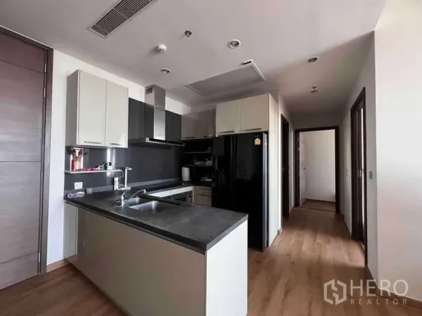 公寓 出售在Watthana, Bangkok - 现代化厨房，带中岛、黑色石材台面与内置柜，木地板。