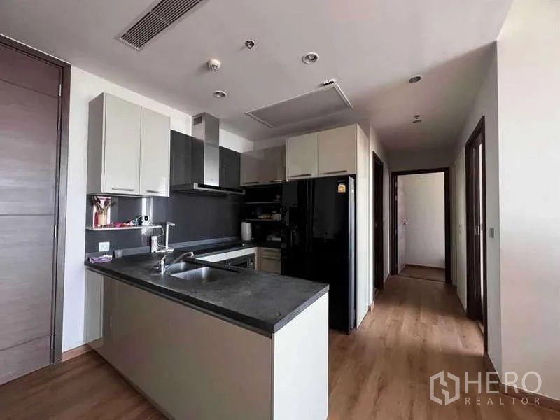 公寓 出售在Watthana, Bangkok - 现代化厨房，带中岛、黑色石材台面与内置柜，木地板。