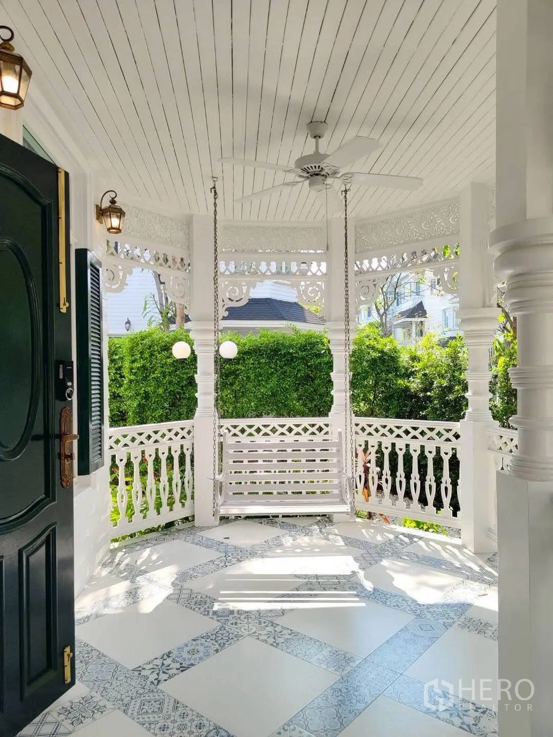 Detached House for rent in Bang Na, Bangkok - Ornate covered porch with ceiling fan and hanging bench swing.