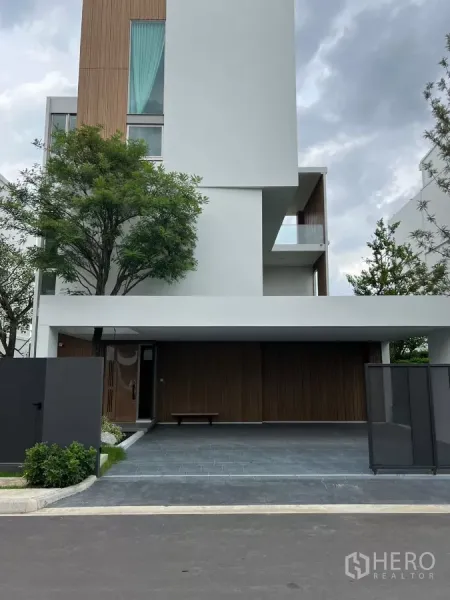 Detached House for rent in Saphan Sung, Bangkok - Modern multi-storey detached house facade with wood accents and a covered double carport.