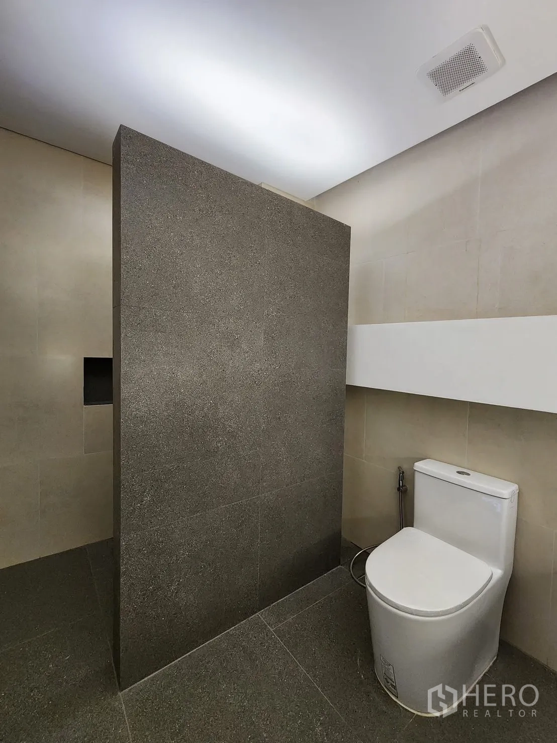 家庭办公室 for rent in Chatuchak, Bangkok - 极简卫生间，灰色瓷砖隔断和现代坐便器。