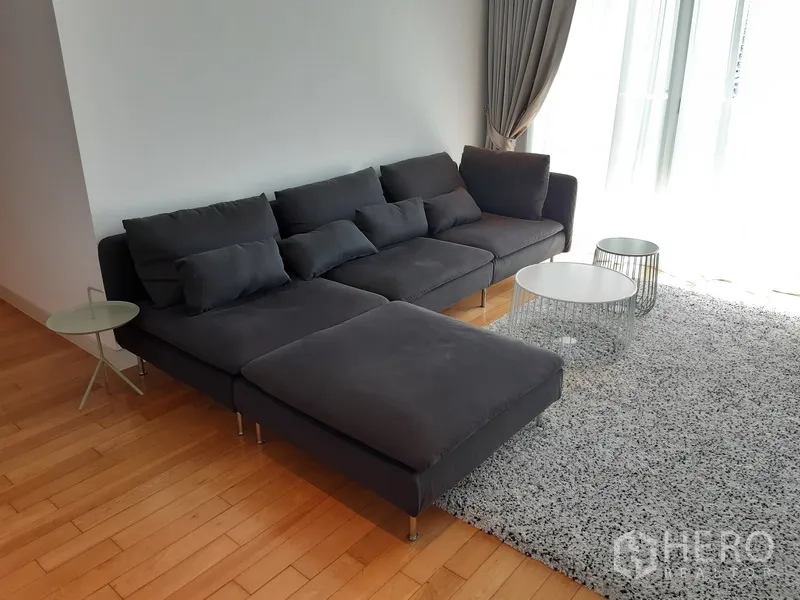 คอนโด ให้เช่าในKhlong Toei, Bangkok - ห้องนั่งเล่นสว่าง โซฟาเข้ามุมสีเทา พื้นไม้ และผ้าม่านสูงจรดเพดาน