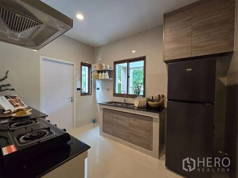 独立式住宅 出租在Bang Kapi, Bangkok - 明亮泰式厨房，水槽窗与木质橱柜。