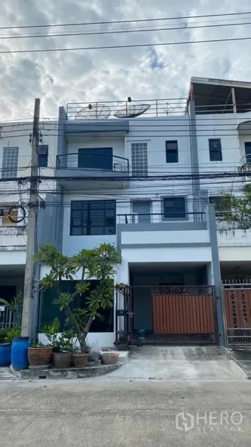 联排别墅 出租在Bang Na, Bangkok - 曼谷邦纳三层联排别墅外观，带有门禁车位与盆栽。