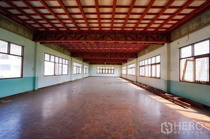 零售空间 出租在Watthana, Bangkok - 宽敞开放式零售空间，拼花木地板、红色桁架天花与多扇采光窗。