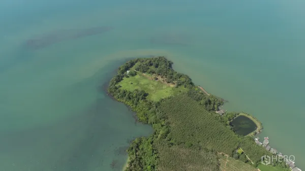 Land for sale in Khlong Toei, Bangkok - Wide aerial panorama showing a private headland with open meadows and forest edges extending into the sea.