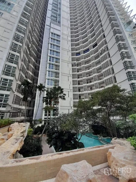 คอนโด ให้เช่าหรือขายในPathum Wan, Bangkok - อาคารคอนโดมิเนียมไฮไรส์สมัยใหม่ หน้าตาโค้ง รายล้อมด้วยต้นปาล์มและสระว่ายน้ำสวน