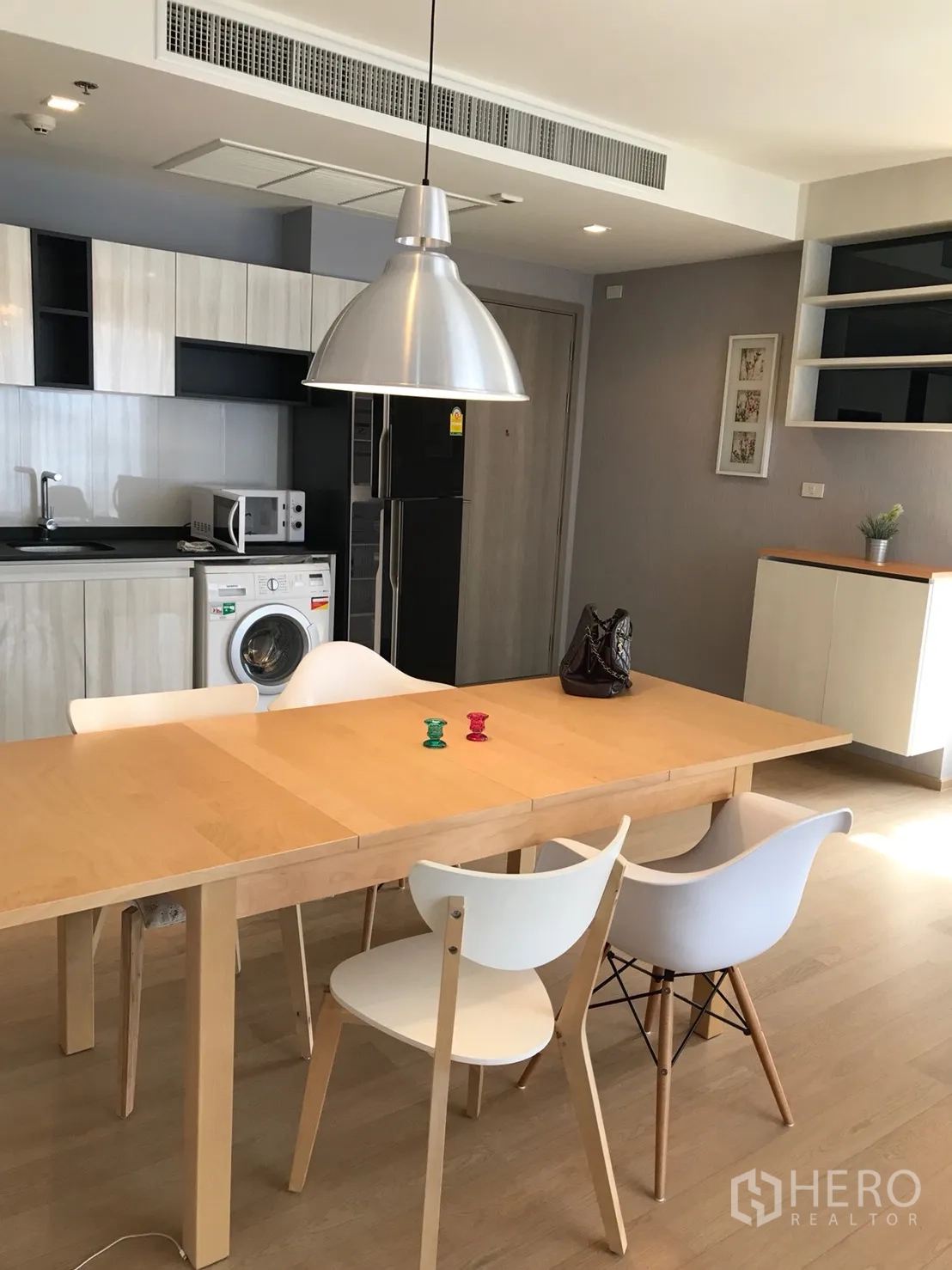 Condominium for rent or sale in Watthana, Bangkok - Open kitchen and dining zone with built-in cabinets, fridge and washing machine.