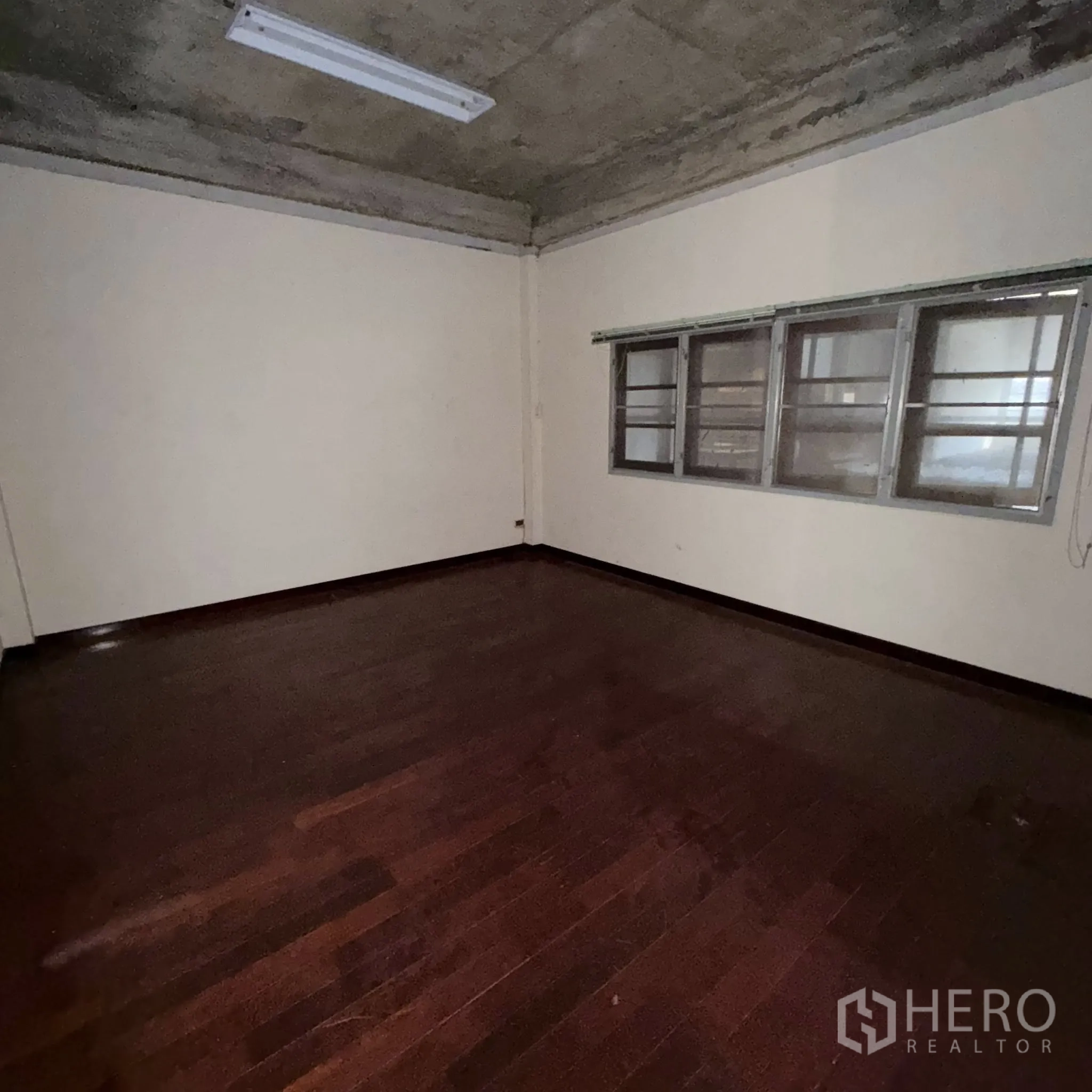 工厂 for rent in Phra Pradaeng, Samut Prakan - 简洁办公室，深色木地板与日光灯照明。