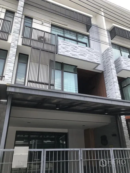 Home Office for rent or sale in Bang Phli, Samut Prakan - Modern three-storey townhouse facade with balcony and gated carport.
