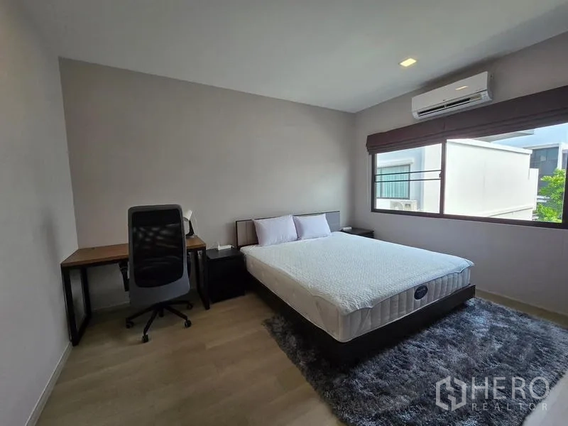 ทาวน์เฮาส์ ให้เช่า - ห้องนอนแขกสว่างพร้อมโต๊ะทำงาน หน้าต่างบานใหญ่ และแอร์
