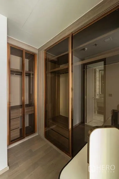 Condominium for rent - Walk‑in closet with glass‑front wardrobes and wood flooring.