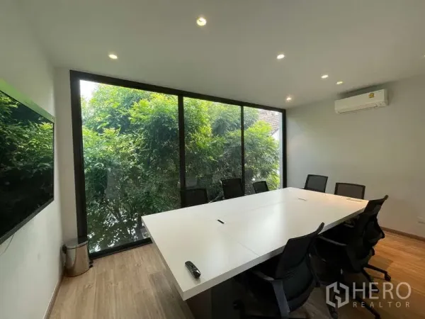 สำนักงานที่บ้าน ให้เช่าในDon Mueang, Bangkok - ห้องประชุมผนังกระจก โต๊ะประชุมและเก้าอี้ มองเห็นวิวต้นไม้เขียว