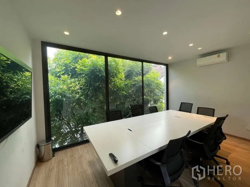 สำนักงานที่บ้าน ให้เช่าในDon Mueang, Bangkok - ห้องประชุมผนังกระจก โต๊ะประชุมและเก้าอี้ มองเห็นวิวต้นไม้เขียว