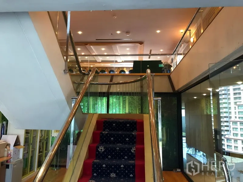 Office Space for rent in Bang Na, Bangkok - Staircase landing with glass walls and city views beside the office mezzanine.