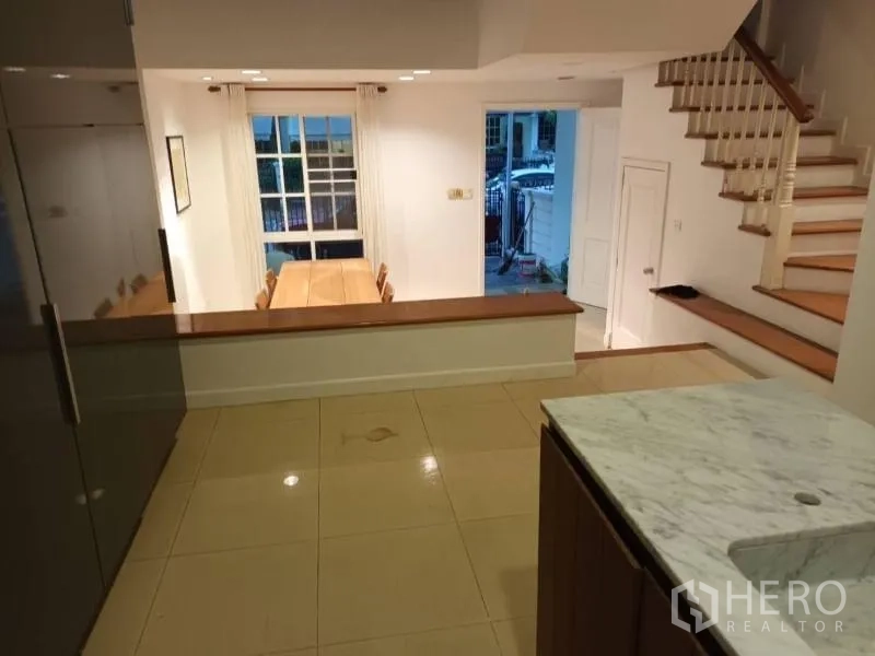 Townhouse for rent in Bang Kapi, Bangkok - Split-level view from the kitchen overlooking the dining area and entryway with stairs.