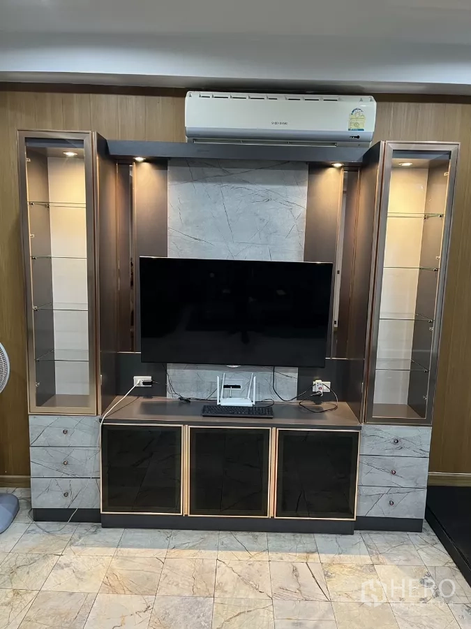 Home Office for rent - Built‑in TV wall with marble accents and an air conditioner above