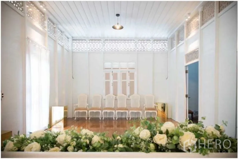 Detached House for rent in Bang Rak, Bangkok - Large white multipurpose room with wooden floor, decorative lattice and a row of chairs.