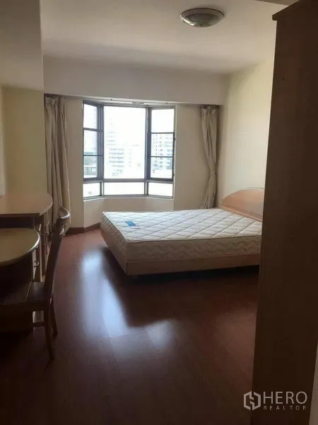 Condominium for rent in Watthana, Bangkok - Second bedroom with bay window, study desk, and queen bed receiving natural light.