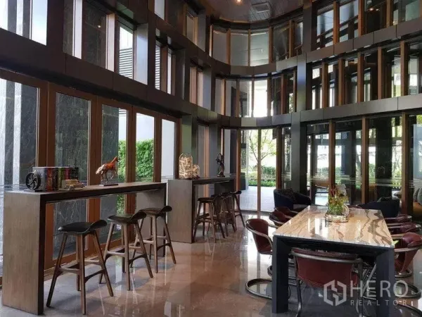 คอนโด ให้เช่าหรือขาย - โคเวิร์กกิงเลานจ์เพดานสูง ผนังกระจกเต็มบาน พร้อมโต๊ะบาร์และสตูล