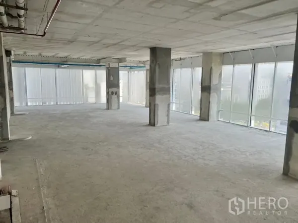 Office Space for rent in Sathon, Bangkok - Bright unfinished office space featuring panoramic glazing, high concrete ceiling and regular column grid.