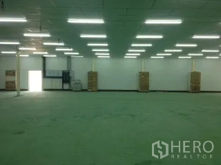Warehouse for rent in Nakhon Ratchasima - Open warehouse interior with bright LED lighting, high ceiling and green epoxy flooring.
