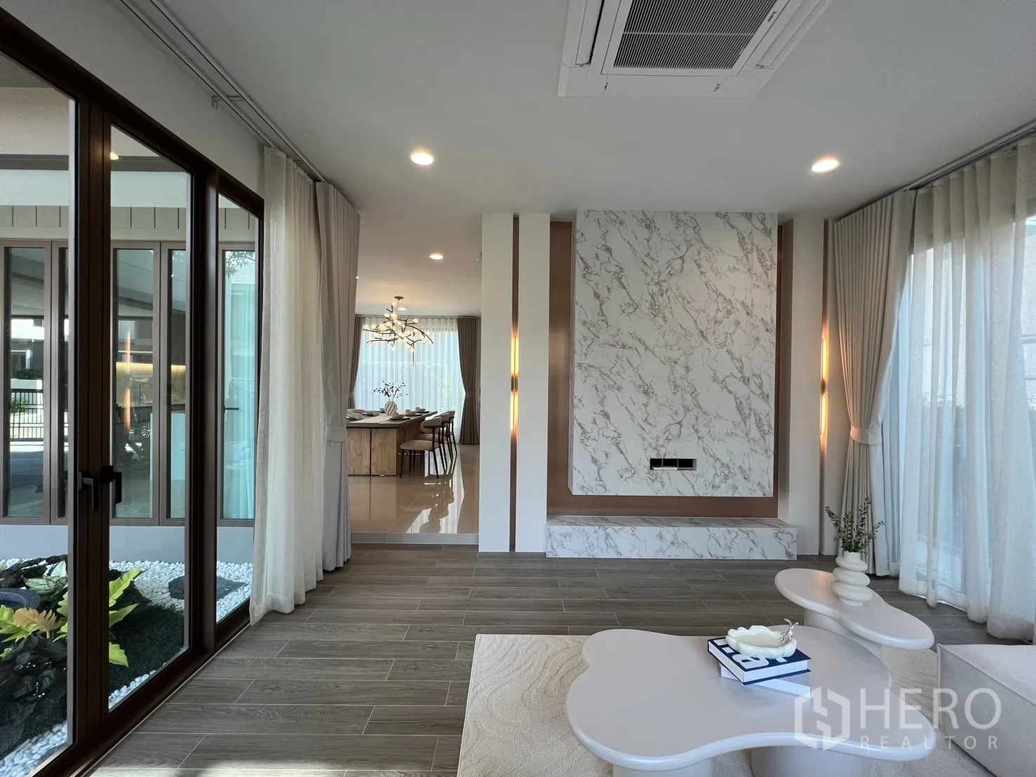 Detached House for rent or sale in Bang Kapi, Bangkok - Living room opening to the courtyard via sliding glass doors with view toward the dining area.