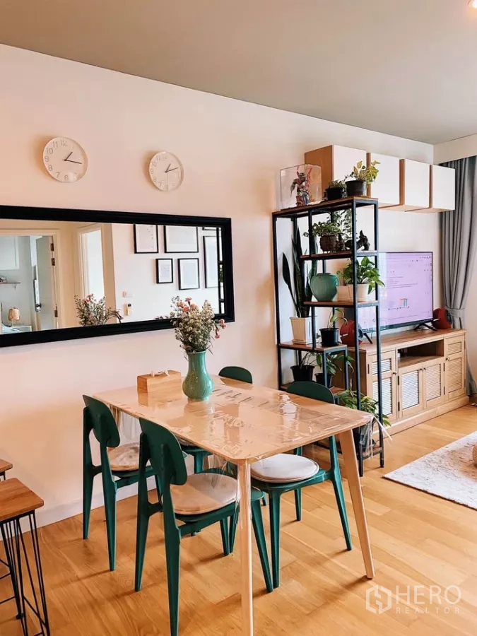 Condominium for rent in Watthana, Bangkok - Dining corner with four-seat table, long wall mirror and indoor plants beside the TV unit.
