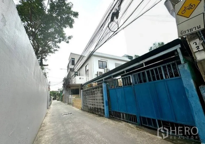 Shophouse for rent in Bang Rak, Bangkok - Narrow alley beside a blue gate and low-rise buildings near BTS Chong Nonsi in Silom.