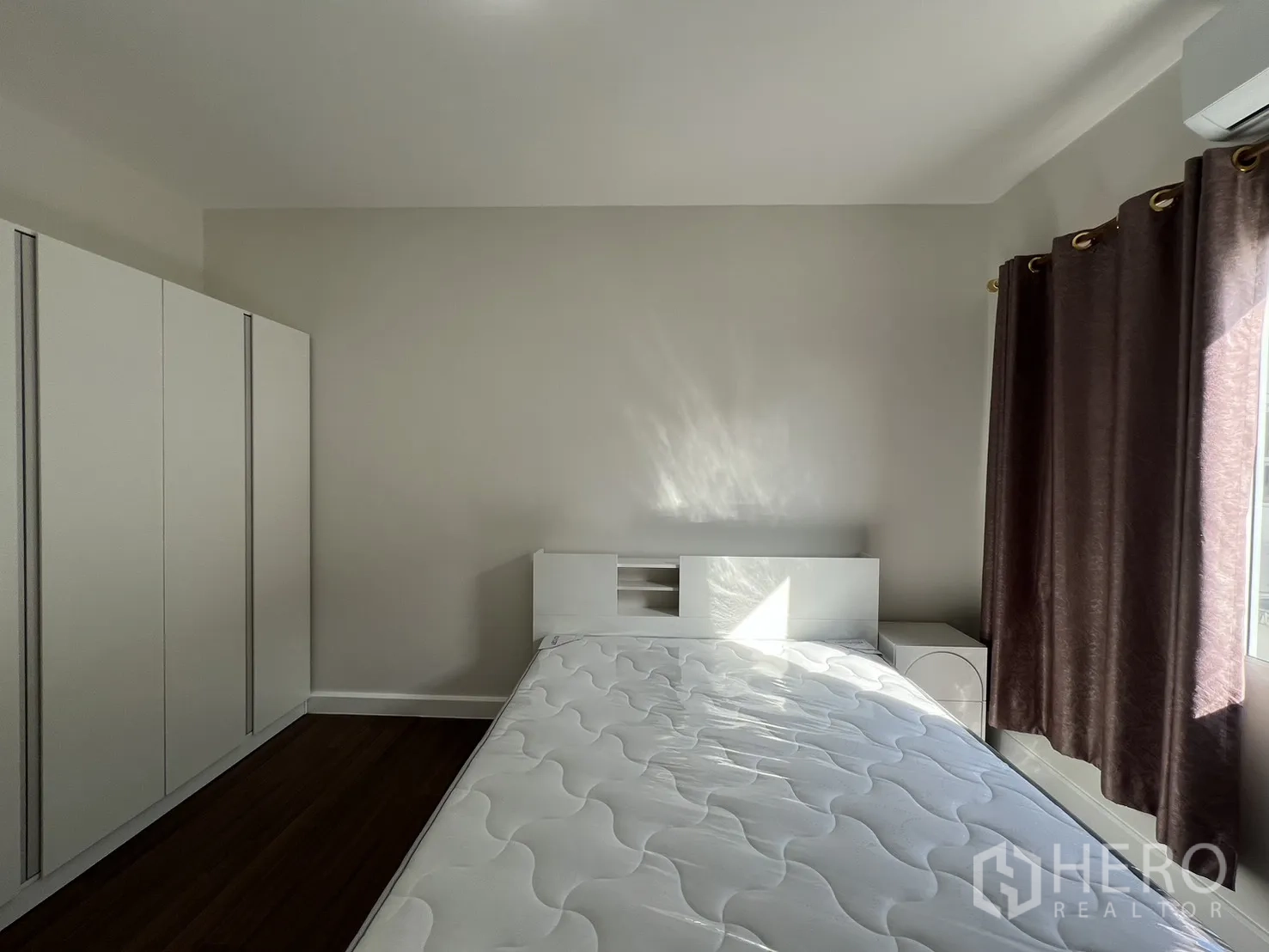 Townhouse for rent in Bang Kapi, Bangkok - Bedroom showing bed and wardrobe by the window.