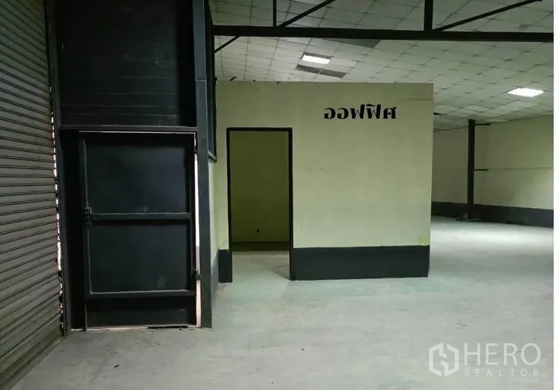 货栈 出租在Bang Khen, Bangkok - 仓库内部的办公室房间，紧邻大型卷帘门。
