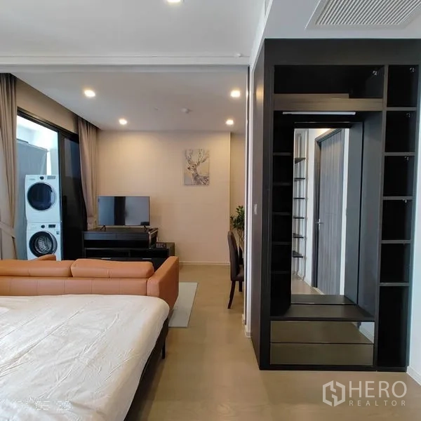 Condominium for rent in Watthana, Bangkok - Bedroom with king bed, leather sofa, built-in wardrobe and access to the balcony laundry.