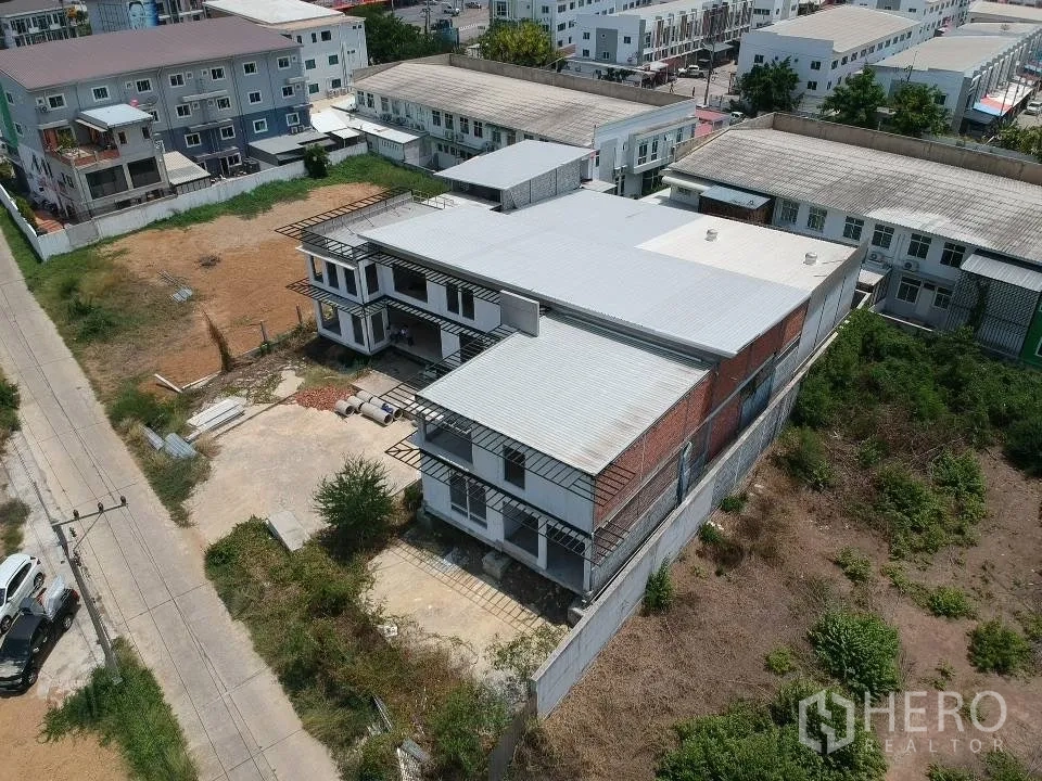 Land for sale in Phra Nakhon Si Ayutthaya, Phra Nakhon Si Ayutthaya - Rear‑angle drone photo of a warehouse‑style structure within a walled land plot and natural vegetation.