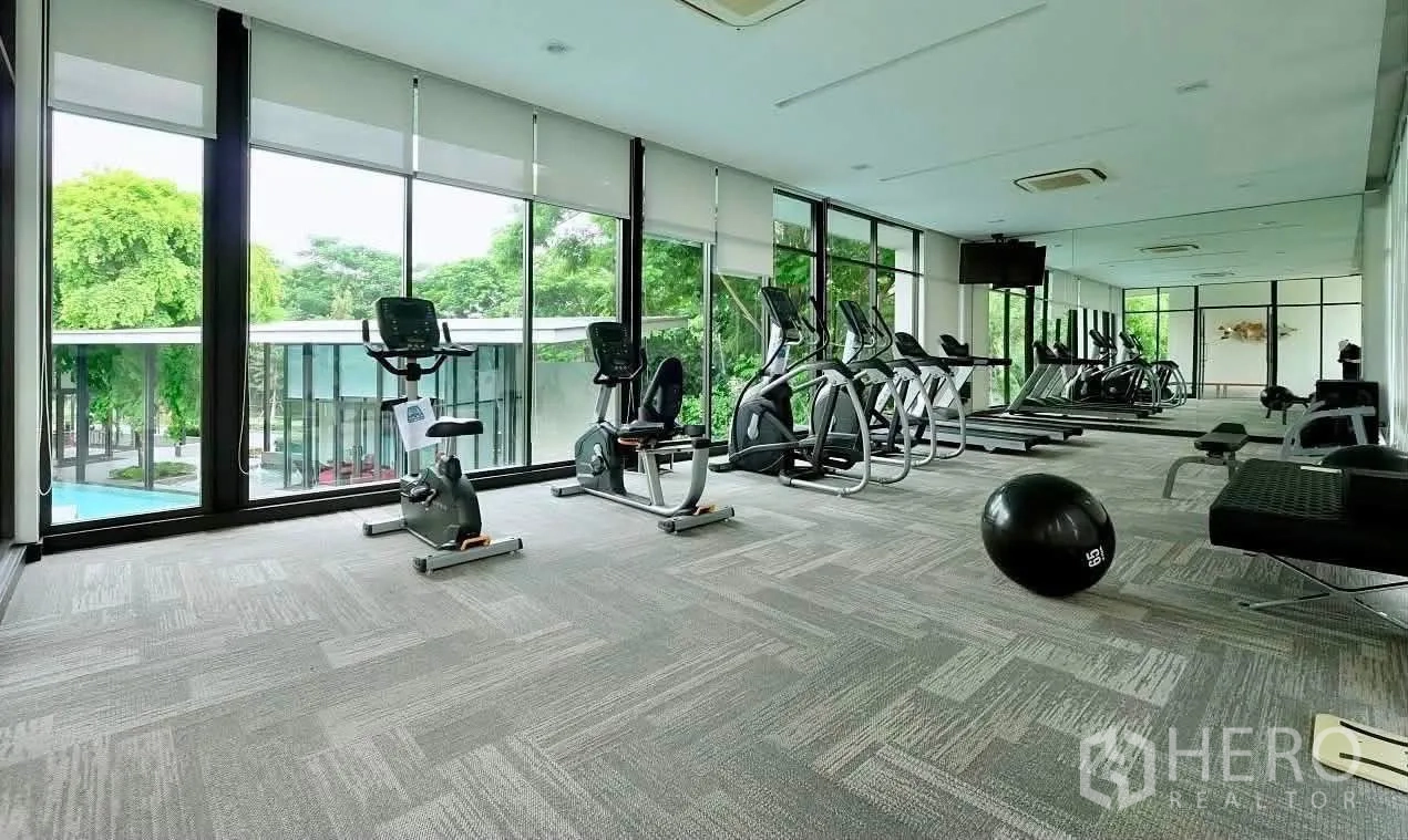 Townhouse for rent in Lat Phrao, Bangkok - Fitness room with treadmills, ellipticals, bikes and floor-to-ceiling windows.