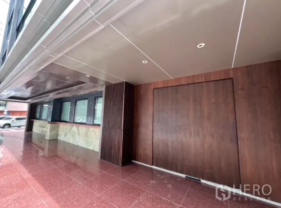 พื้นที่ขายปลีก ให้เช่าในKhlong Toei, Bangkok - ด้านหน้าตึกมีหลังคาคลุม ผนังไม้และประตูบานใหญ่ พื้นหินสีแดง