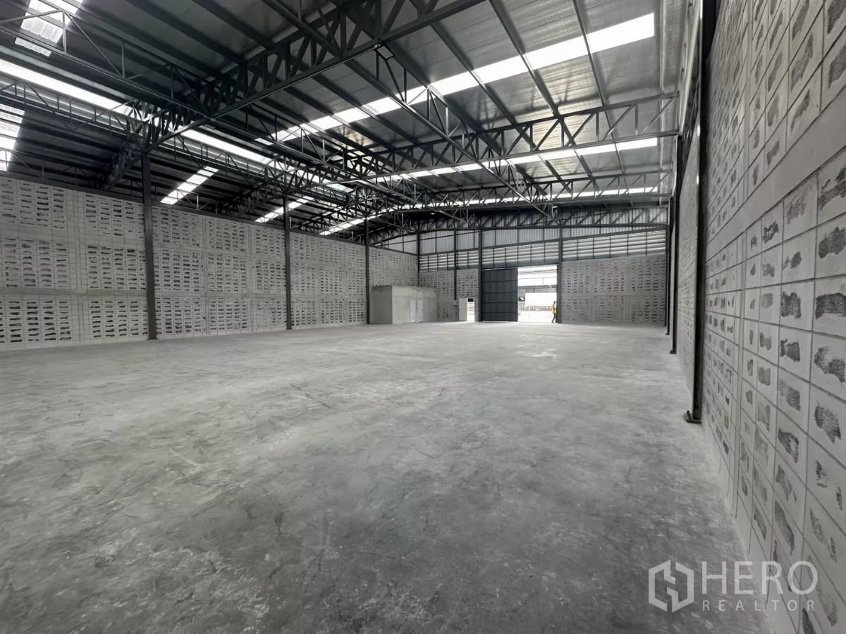 Warehouse for rent in Khlong Toei, Bangkok - Spacious warehouse interior with high steel truss roof, skylights and smooth concrete floor.