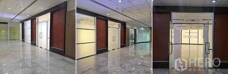 办公空间 出租在Phaya Thai, Bangkok - 大理石走廊与木质墙面，通往办公室的玻璃双开门入口。