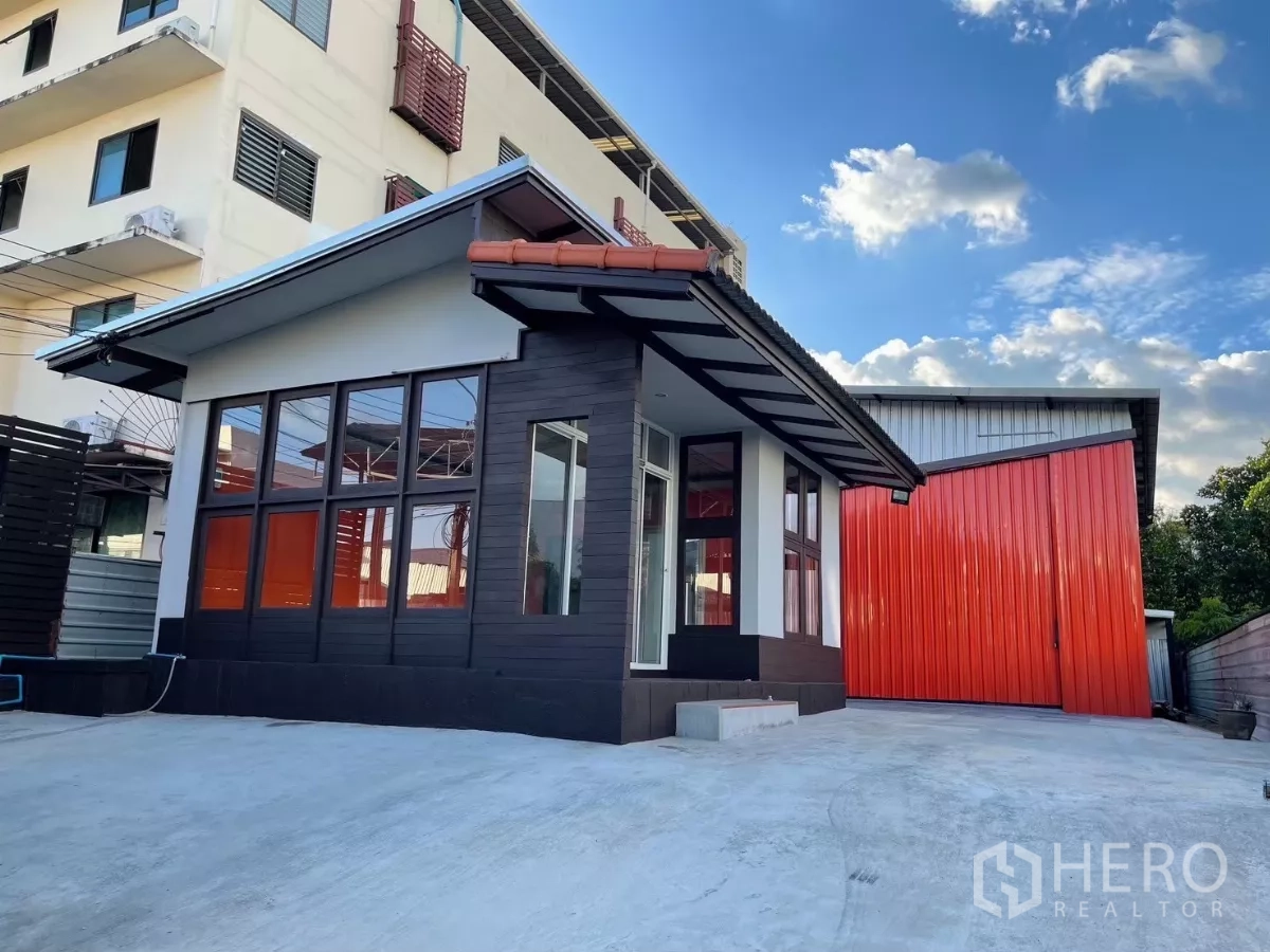 货栈 出租在Khlong Toei, Bangkok - 办公室一角与红色仓库外立面，前方装卸场地宽敞。