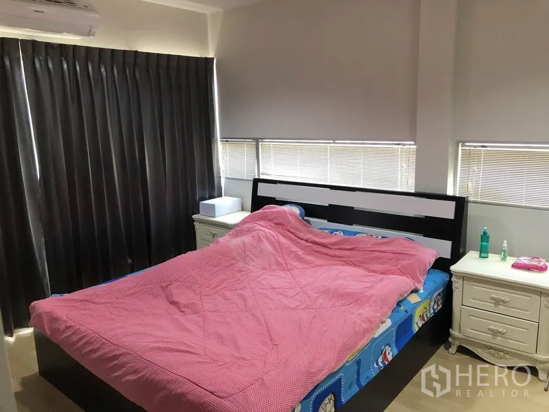 ทาวน์เฮาส์ ให้เช่าหรือขายในSuan Luang, Bangkok - ห้องนอนรอง เตียงคู่ ผ้าห่มสีชมพู ม่านทึบ และหน้าต่างมุมพร้อมมู่ลี่